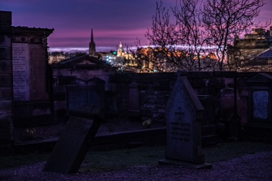 Gravestones under a violet sky at dusk on an Edinburgh ghost walk